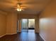 Living area with sliding doors to screened patio, ceiling fan, and wood-look floors at 11321 Flora Springs Dr, Riverview, FL 33579