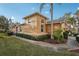 Tan house with palm trees, landscaped yard, and walkway at 1141 Jameson Greens Dr # 3, Sun City Center, FL 33573