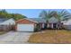 Brick ranch house with a white garage door, palm trees, and a fenced yard at 12819 126Th Ter, Largo, FL 33774