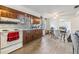 View of kitchen with wood cabinets, white appliances, and laminate floors at 14035 21St St, Dade City, FL 33525