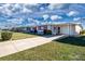 Ranch-style home with carport and landscaped lawn at 1518 Chevy Chase Dr, Sun City Center, FL 33573