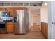 Kitchen with stainless steel appliances and wood cabinets, leading to hallway at 1518 Chevy Chase Dr, Sun City Center, FL 33573