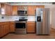 Bright kitchen with stainless steel appliances and wood cabinets at 1518 Chevy Chase Dr, Sun City Center, FL 33573