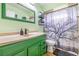 Charming bathroom with green vanity and tree shower curtain at 3411 28Th E St, Bradenton, FL 34208