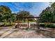 Wooden park swings beneath pergola, near golf course at 36750 Us Highway 19 # 21-301, Palm Harbor, FL 34684