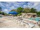 Pool deck with lounge chairs and blue umbrellas at 36750 Us Highway 19 # 21-301, Palm Harbor, FL 34684