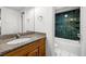 Bathroom with granite vanity, teal tile shower, and white fixtures at 3817 W Platt St # 306, Tampa, FL 33609