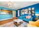 Living room with blue walls, hardwood floors, and gallery wall at 3817 W Platt St # 306, Tampa, FL 33609