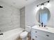 Updated bathroom with gray tile, white vanity, and bathtub at 4039 Eastridge Dr, Valrico, FL 33596