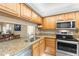 Kitchen with wood cabinets, granite counters, and stainless appliances at 6219 Palma Del Mar S Blvd # 114, St Petersburg, FL 33715