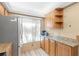 Bright kitchen with wood cabinets, granite counters, and stainless steel appliances at 6219 Palma Del Mar S Blvd # 114, St Petersburg, FL 33715