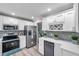 White kitchen cabinets with stainless steel appliances at 6311 Newtown Cir # 11B1, Tampa, FL 33615