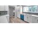 Modern white kitchen with teal dishwasher and quartz counters at 6311 Newtown Cir # 11B1, Tampa, FL 33615