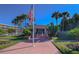 Community clubhouse with a flagpole, lush landscaping, and palm trees at 6363 99Th N Way # 12A, St Petersburg, FL 33708