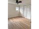 Bedroom with wood-look floors, white trim, window, and double-door closet at 6615 Parkside Dr, New Port Richey, FL 34653