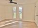 Bedroom featuring wood-look floors, white trim, and two windows at 6615 Parkside Dr, New Port Richey, FL 34653