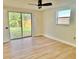 Bright bedroom with a ceiling fan, wood floors, and sliding glass doors to the yard at 6615 Parkside Dr, New Port Richey, FL 34653