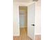 Open closet with white door and trim, rod for hanging clothes, and wood-look floors at 6615 Parkside Dr, New Port Richey, FL 34653