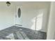 Covered porch with gray tile flooring and a white front door with decorative glass at 6615 Parkside Dr, New Port Richey, FL 34653