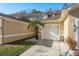 Tan townhome with white garage door, palm tree, and walkway at 8907 Casablanca Way, Tampa, FL 33626