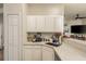 Modern kitchen with white cabinets, quartz countertops, and a corner sink at 8907 Casablanca Way, Tampa, FL 33626