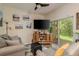 Living room with gray couches, wood floor, and sliding doors to patio at 8907 Casablanca Way, Tampa, FL 33626