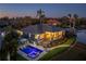 Luxury waterfront home with pool and boat lift at dusk at 930 Monterey Ne Pt, St Petersburg, FL 33704