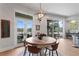 Bright dining area with round wooden table, four chairs, and sliding glass doors leading to a patio with water views at 930 Monterey Ne Pt, St Petersburg, FL 33704