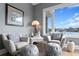 Relaxing sitting area with two armchairs, ottomans, and a large window offering water views at 930 Monterey Ne Pt, St Petersburg, FL 33704