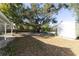 Backyard with shed, patio, and large oak tree providing shade at 10215 Evening Trail Dr, Riverview, FL 33569
