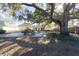 Large backyard with patio, picnic tables, and mature oak tree at 10215 Evening Trail Dr, Riverview, FL 33569