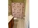 Bathroom with a floral shower curtain and double vanity at 1213 Huntington Greens Dr, Sun City Center, FL 33573