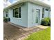 Side view of a house with a patio and additional storage area at 1213 Huntington Greens Dr, Sun City Center, FL 33573