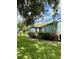 Side view of a light blue house with red flowers and lush landscaping at 1213 Huntington Greens Dr, Sun City Center, FL 33573
