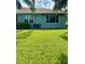 Backyard view of a house with a large green lawn at 1213 Huntington Greens Dr, Sun City Center, FL 33573