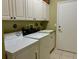 Laundry room with built-in cabinets and a utility sink at 1213 Huntington Greens Dr, Sun City Center, FL 33573