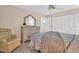Bedroom with dresser, ceiling fan, and a comfortable armchair at 1613 Heather Pl, Palm Harbor, FL 34684