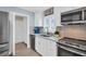 Modern kitchen with white cabinets, granite countertops, and stainless steel appliances at 1613 Heather Pl, Palm Harbor, FL 34684
