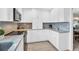 Modern kitchen with white cabinets, granite countertops, and stainless steel appliances at 1613 Heather Pl, Palm Harbor, FL 34684