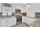 Modern kitchen with white cabinets, granite countertops, and stainless steel appliances at 1613 Heather Pl, Palm Harbor, FL 34684