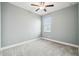 Simple bedroom with gray walls and carpet, featuring a window with blinds at 18015 Fenders Way, Land O Lakes, FL 34638