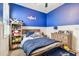 bedroom with blue walls, built-in shelving, and a comfortable bed at 18015 Fenders Way, Land O Lakes, FL 34638