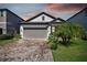 House exterior featuring a gray garage door and brick driveway at 18015 Fenders Way, Land O Lakes, FL 34638