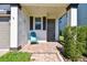 Inviting front porch with a teal chair and brick flooring at 18015 Fenders Way, Land O Lakes, FL 34638