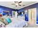 Main bedroom with blue walls, a large bed, and a view into a connected bathroom at 18015 Fenders Way, Land O Lakes, FL 34638