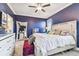 Spacious main bedroom with dark blue walls and a large bed, featuring a full-length mirror at 18015 Fenders Way, Land O Lakes, FL 34638