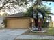 House exterior featuring a two-car garage and well-manicured landscaping at 18116 Portside St, Tampa, FL 33647