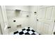 Convenient laundry room with checkerboard floor and shelving at 19130 Wood Sage Dr, Tampa, FL 33647