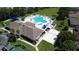 An aerial view showing the community pool, clubhouse and tennis courts at 2749 Plantain Dr, Holiday, FL 34691