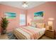 Pastel pink bedroom featuring a comfortable bed and beach-themed decor at 2749 Plantain Dr, Holiday, FL 34691